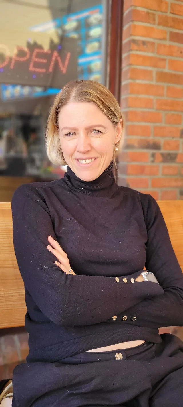 Lea Jansen sitzt lächelnd vor einem Café
